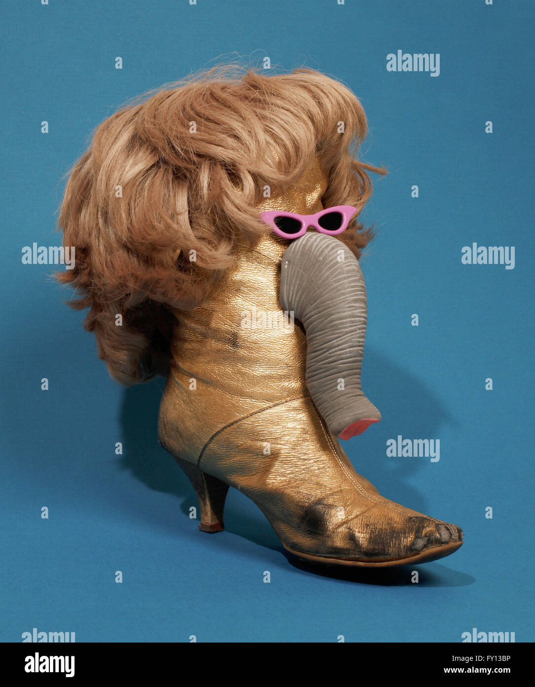 Elephant made from boot and wig over blue background Stock Photo