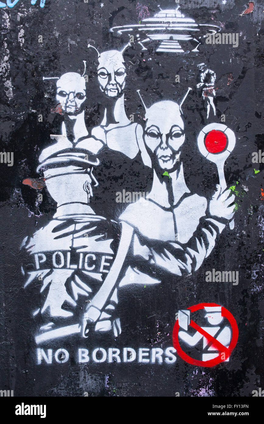 Graffiti showing a policeman stopping aliens with words 'No borders' written below it. It refers to the current migration crisis Stock Photo