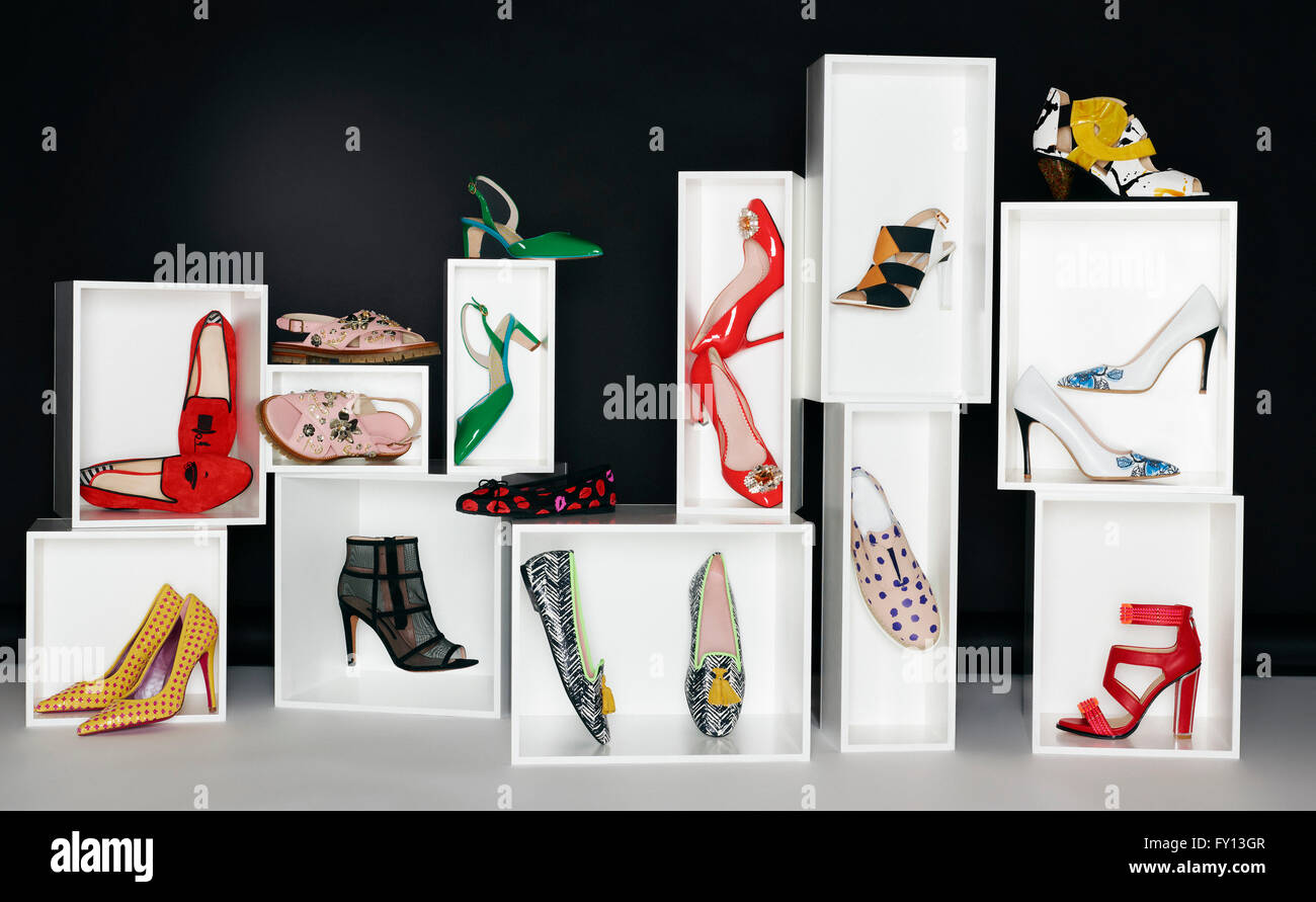 Various pair of shoes in boxes arranged against black background Stock Photo
