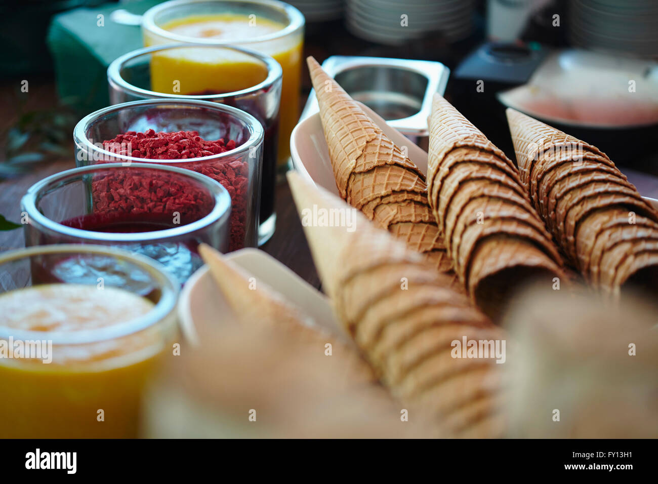 Ice cream cones and various flavored syrups at store Stock Photo