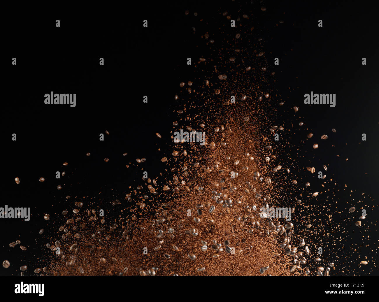 Ground coffee beans in mid-air against black background Stock Photo