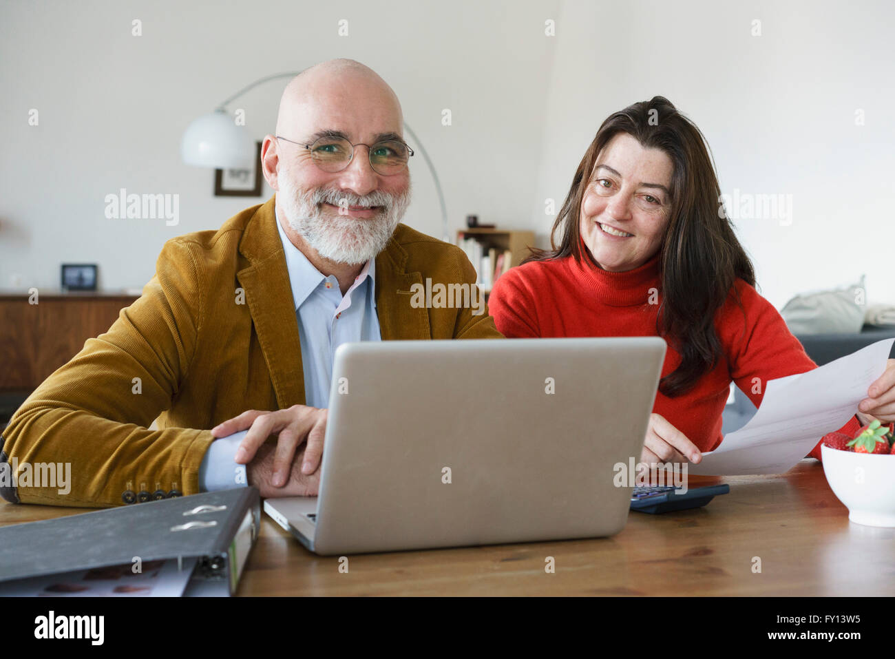 Portrait of mature couple using laptop at home Stock Photo