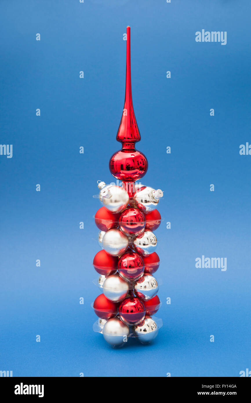 Tree topper on top of red and silver Christmas ornaments against blue background Stock Photo