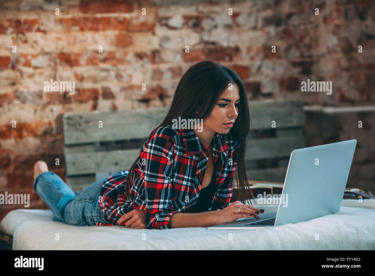 Young woman using laptop while lying on bed at home Stock Photo - Alamy