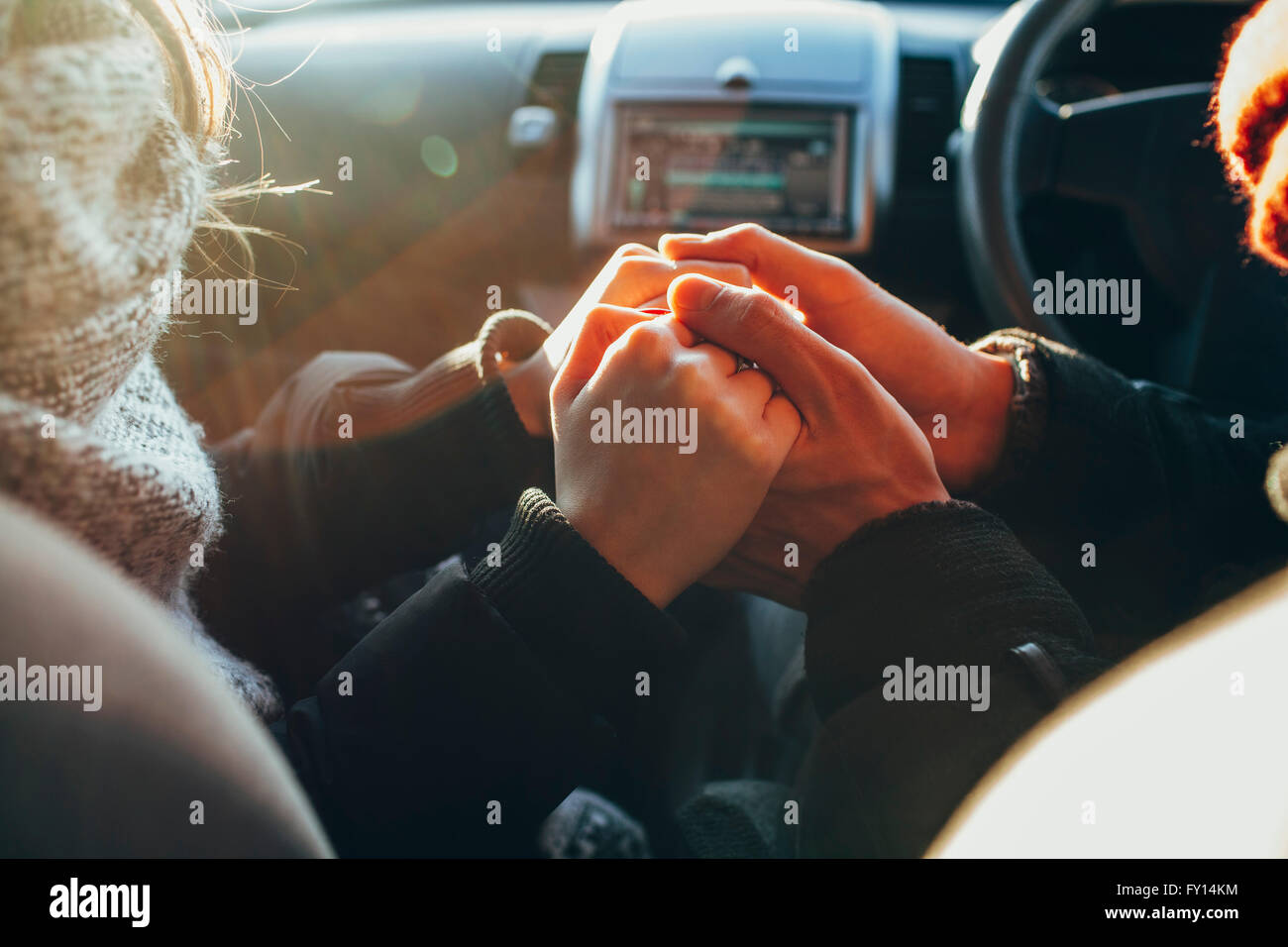 Cropped image of couple holding hands in car Stock Photo