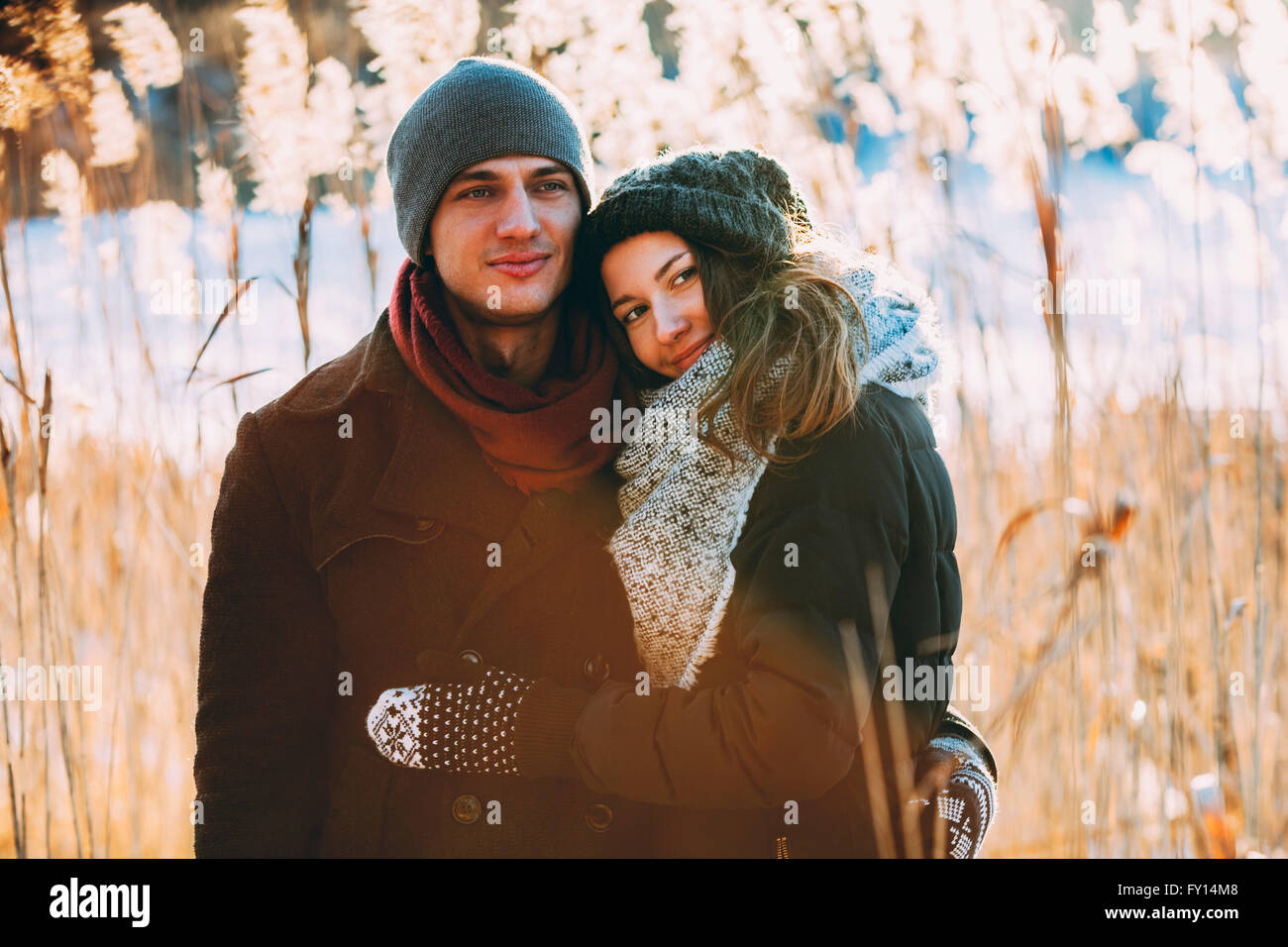 Young couple embracing while standing on field Stock Photo
