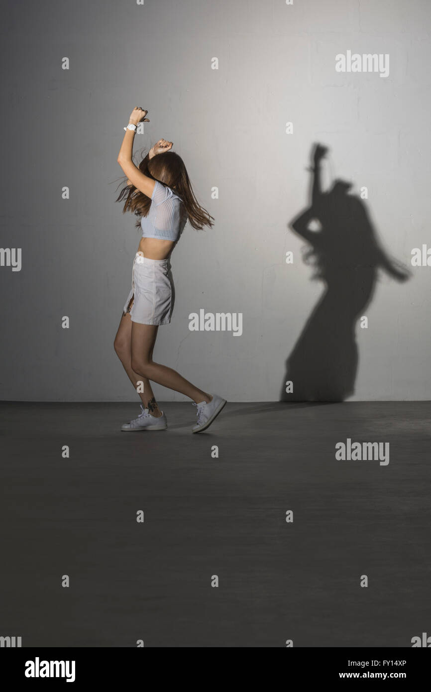 Full length of woman dancing against gray background Stock Photo