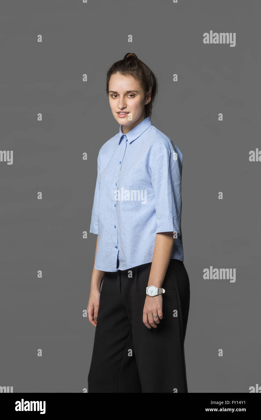 Portrait of confident woman standing against gray background Stock Photo