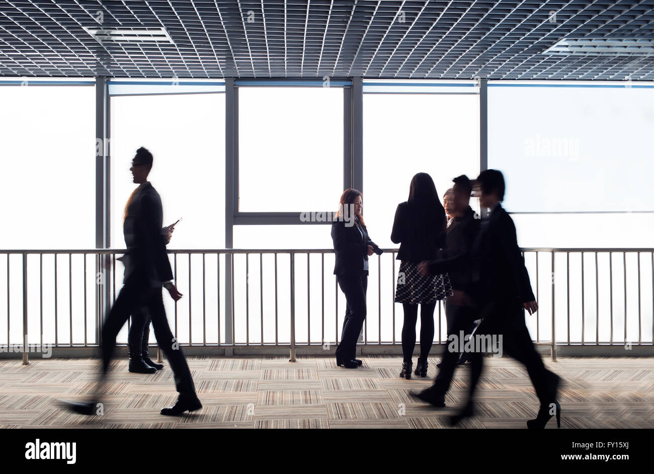 In the office corridor, the silhouette of the business team. Stock Photo