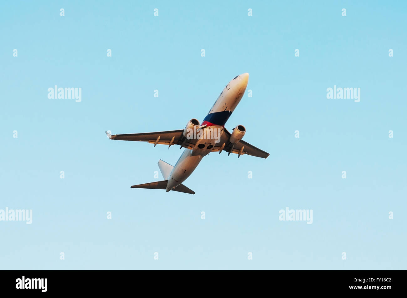 Airplane flying on sky sunset in color of evening light Stock Photo