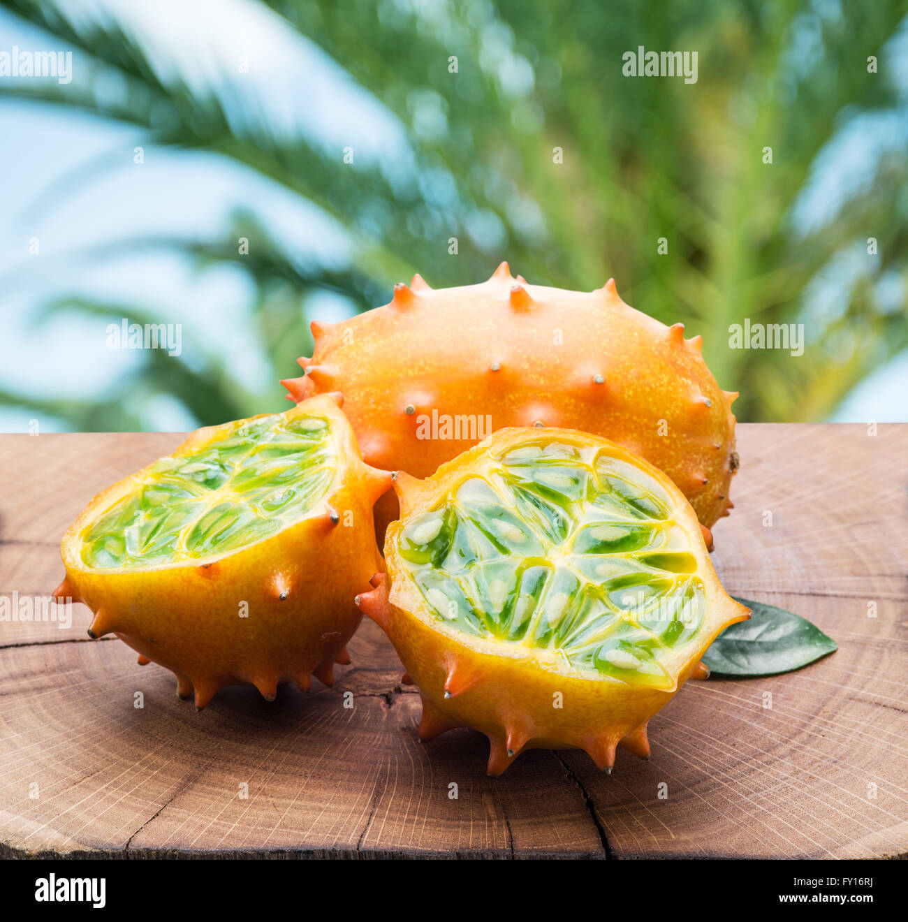 Kiwano fruits on the wooden table with green nature on the background. Stock Photo