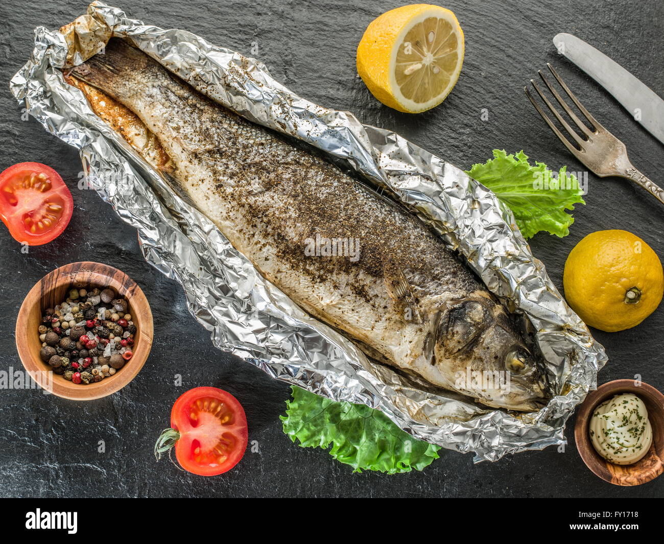 Grilled sea bass fish on the gray table. Stock Photo