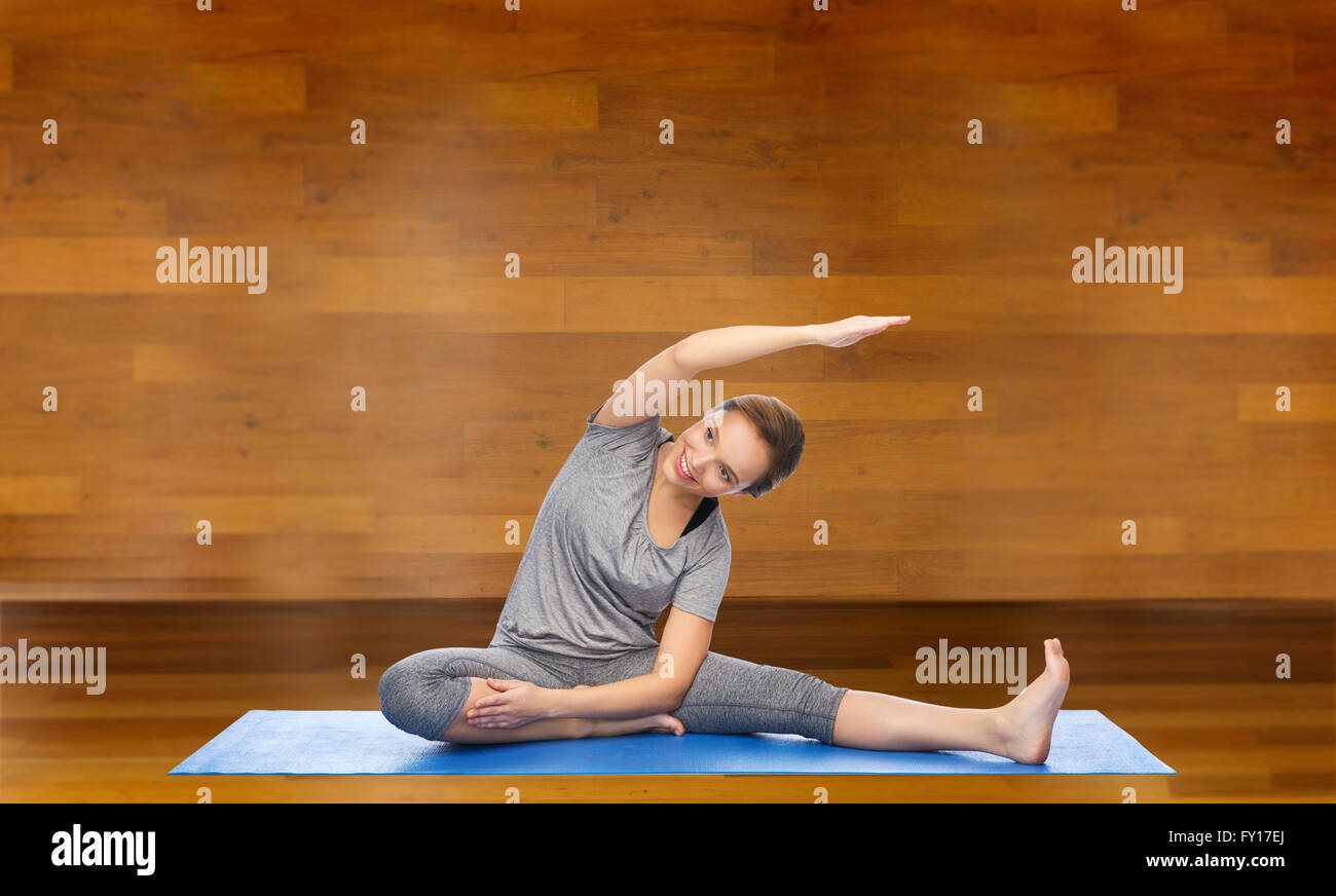 happy woman making yoga and stretching on mat Stock Photo - Alamy