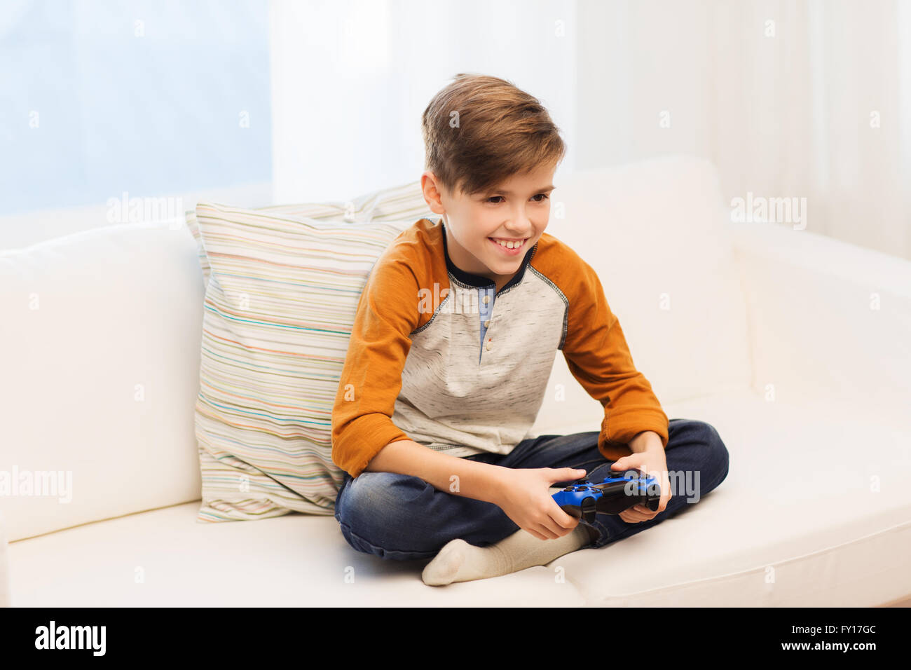 happy boy with joystick playing video game at home Stock Photo - Alamy