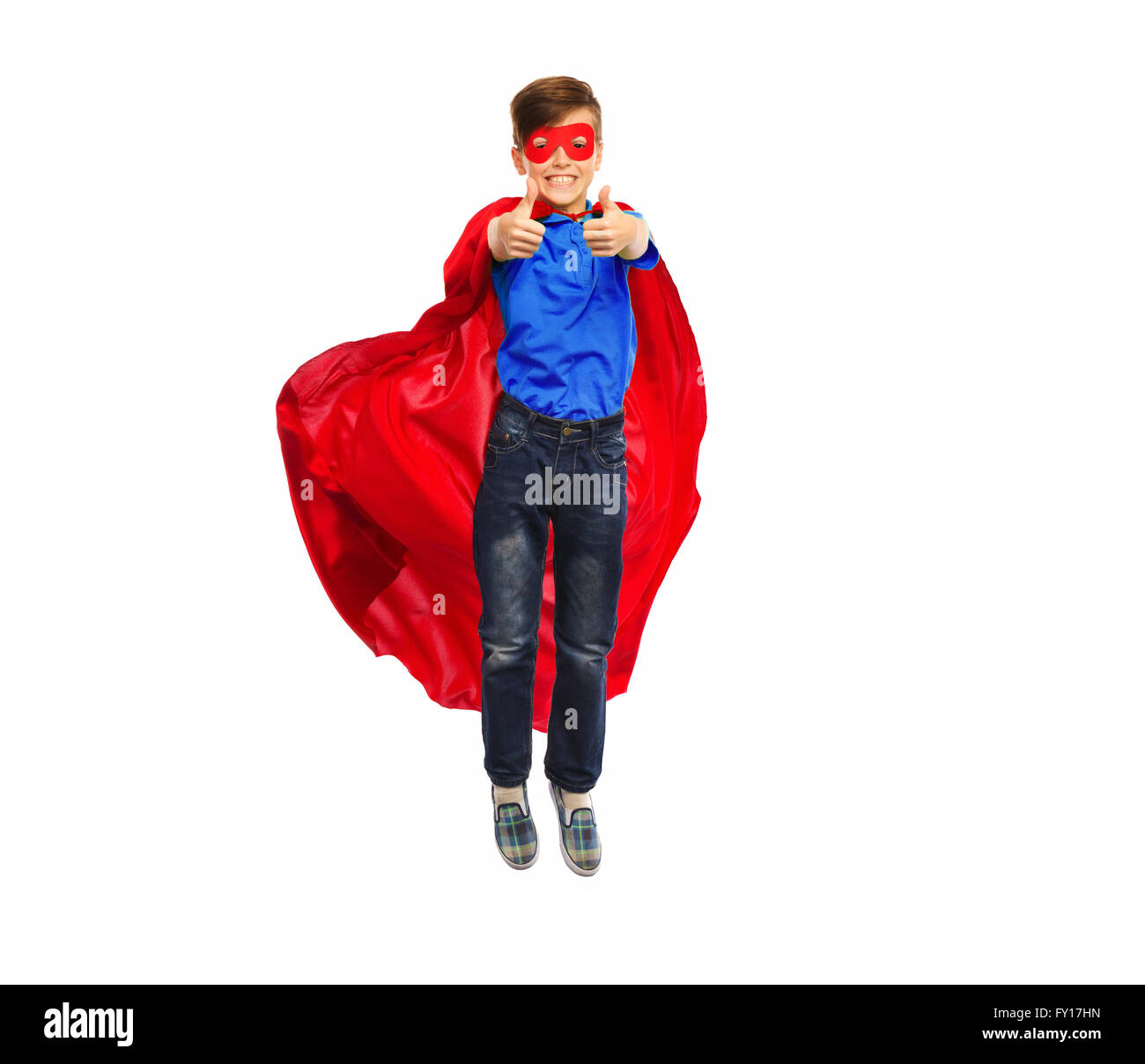boy in super hero cape and mask showing thumbs up Stock Photo