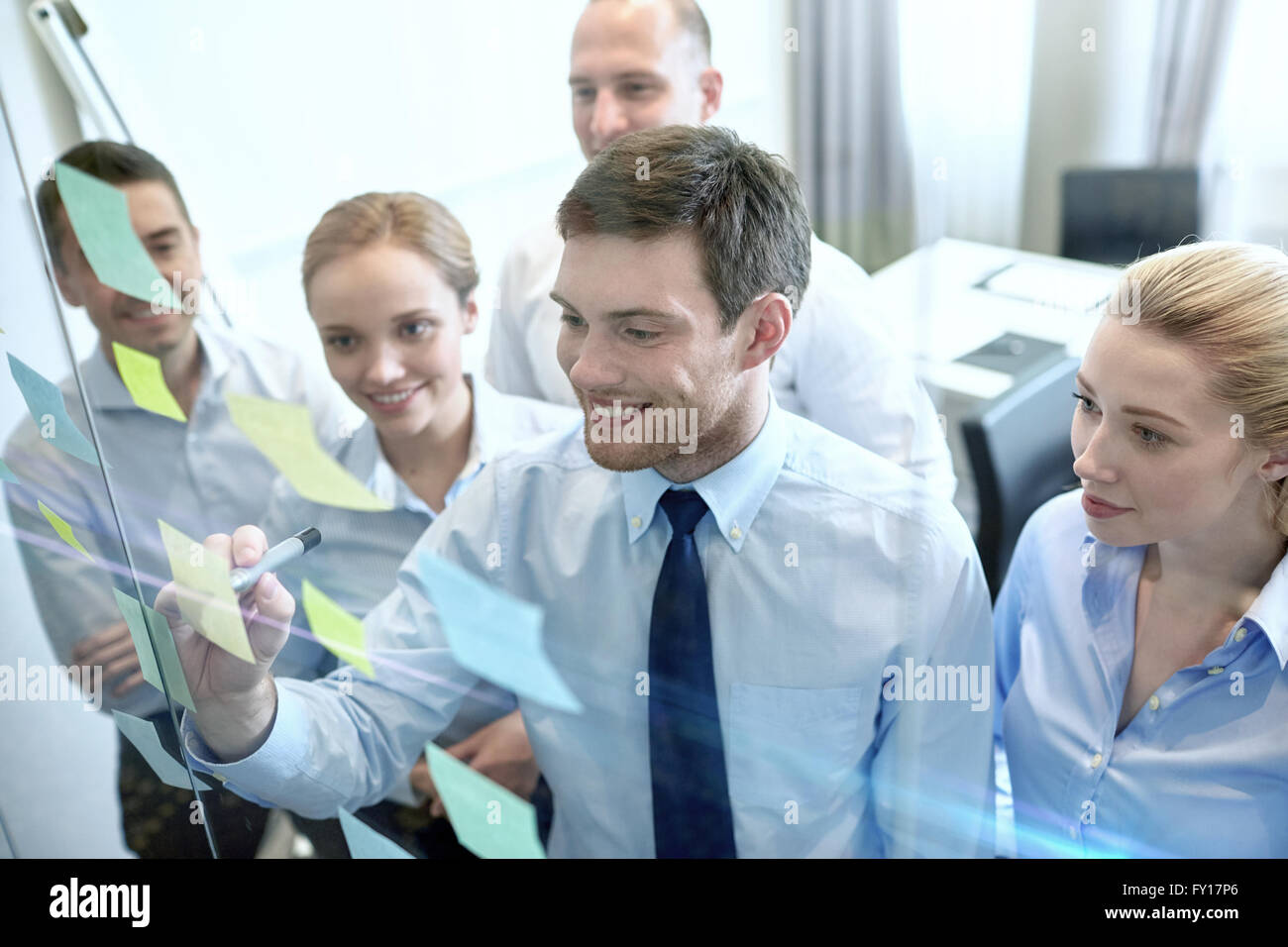 smiling business people with marker and stickers Stock Photo - Alamy