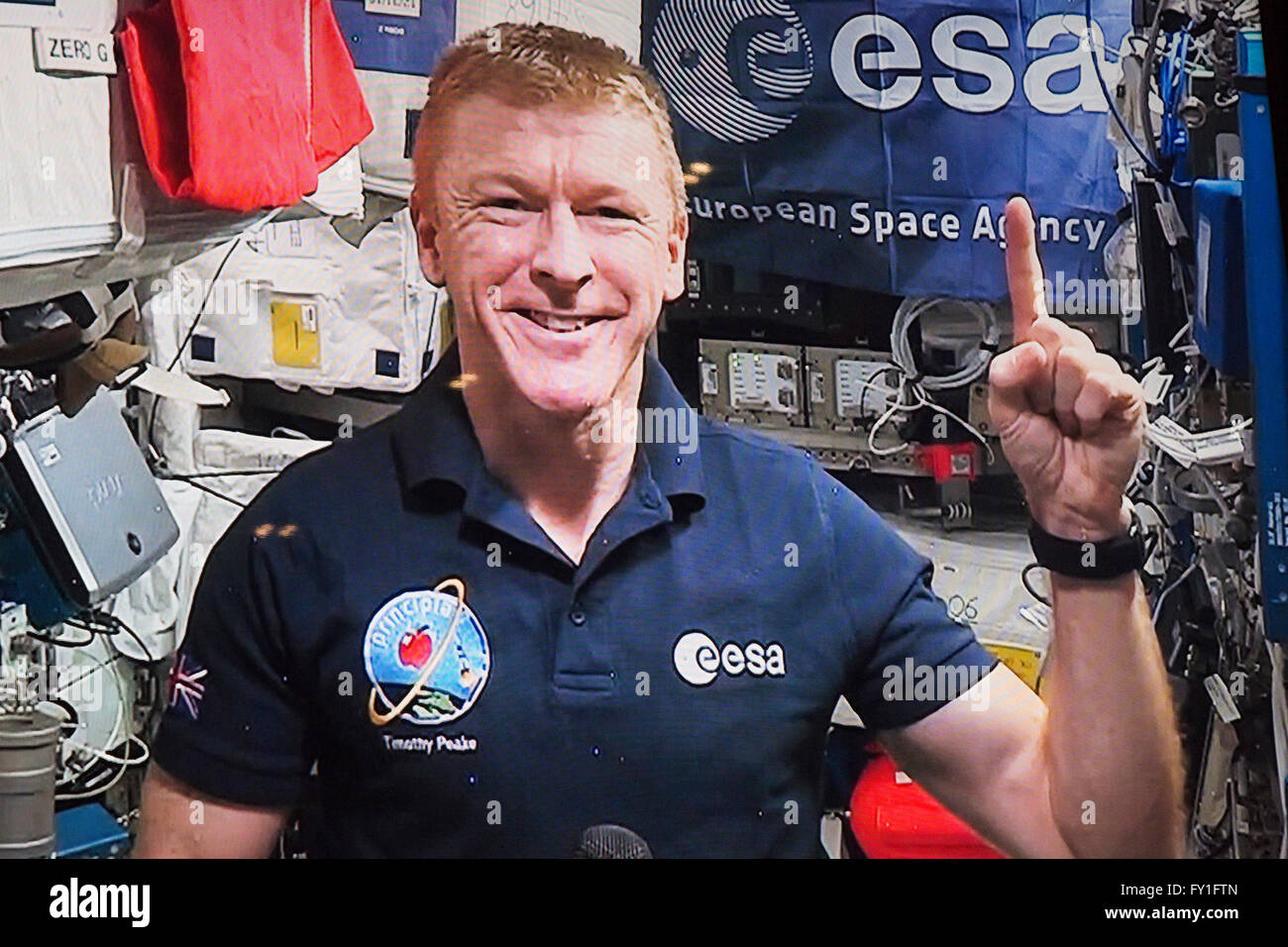 London, UK. 20 April 2016. British Astronaut Tim Peake joins a live press conference at the Tower Hotel in London from the International Space Station. Major Tim Peake will run the Digital Virgin Money London Marathon on a treadmill aboard the International Space Station on Sunday, 24 April 2016 as thousands of participants will run the real-life marathon in London. He makes the #oneinamillion gesture signifying that the millionth finisher will cross the finish line during this year's London Marathon. Credit:  Vibrant Pictures/Alamy Live News Stock Photo