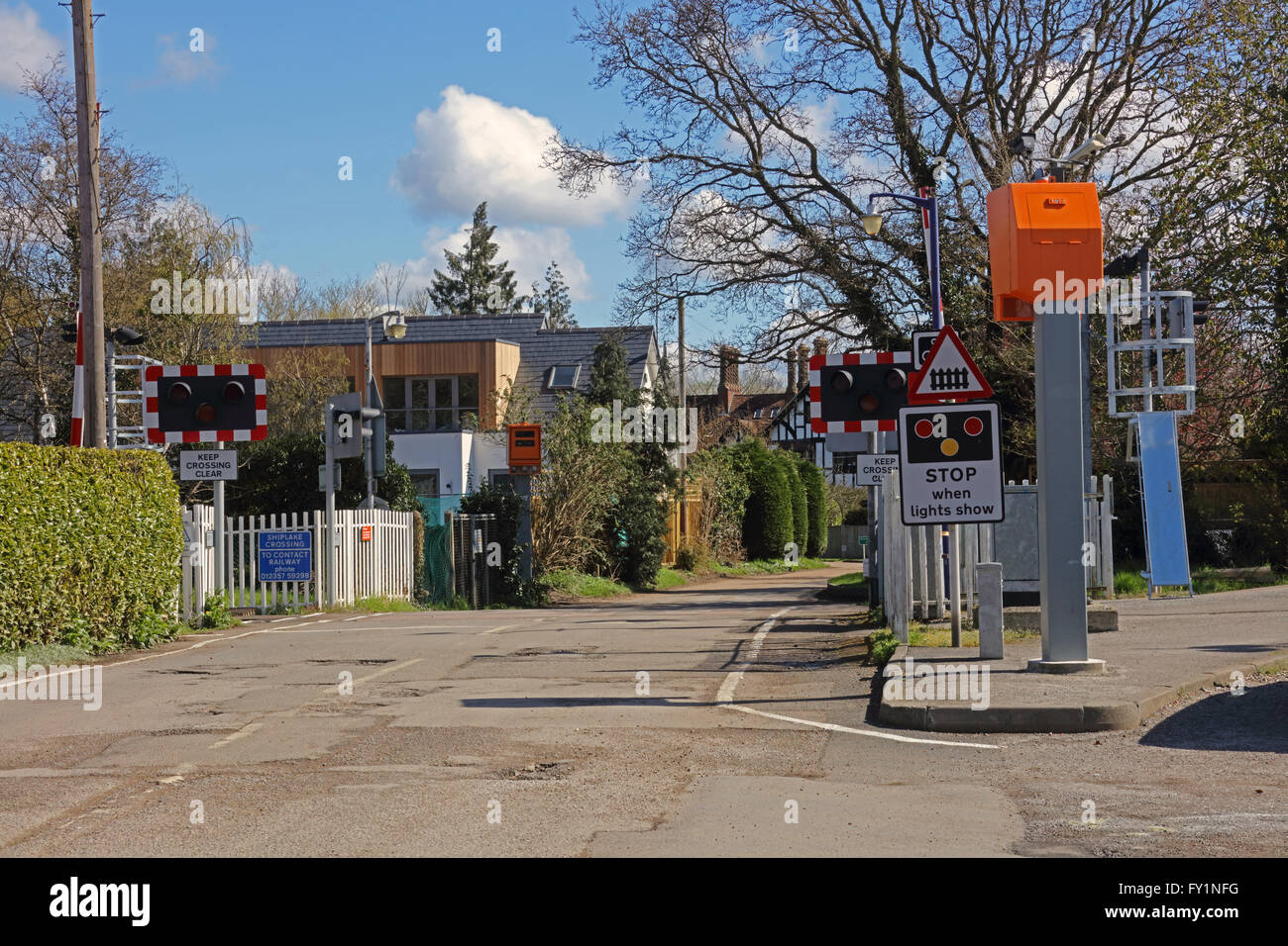 An automatic half barrier level crossing in a rural location with much signage and enforcements camera's on either side. Stock Photo
