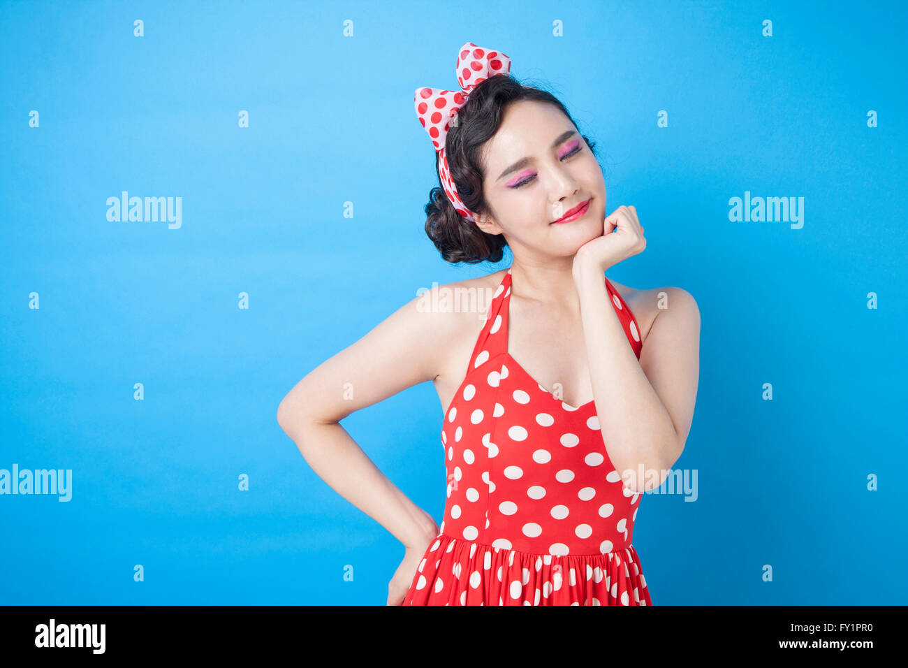 Portrait of young smiling woman posing closing eyes Stock Photo - Alamy