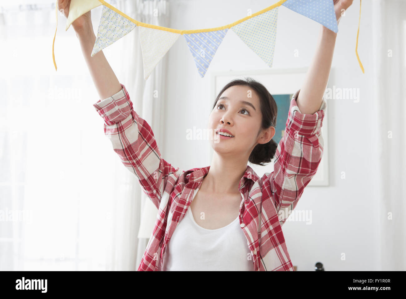Portrait of young smiling woman holding party flags looking up Stock ...