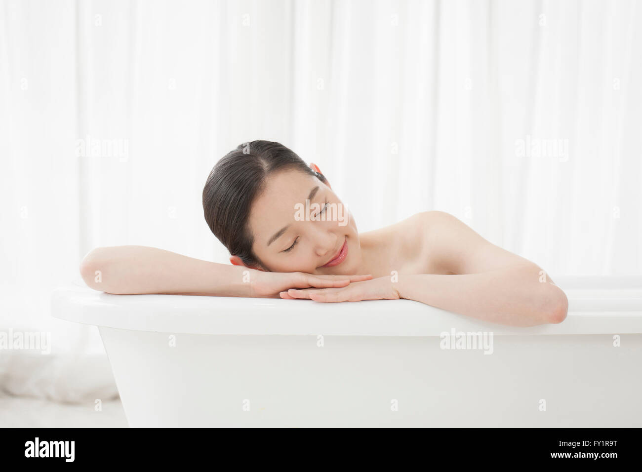 Young woman lying in bathtub hi-res stock photography and images - Alamy