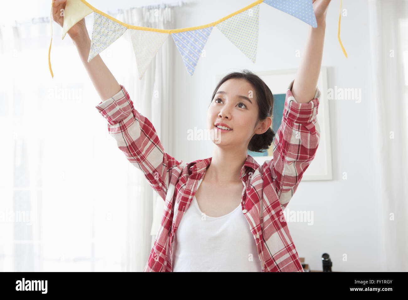 Portrait of young smiling woman holding party flags looking up Stock ...