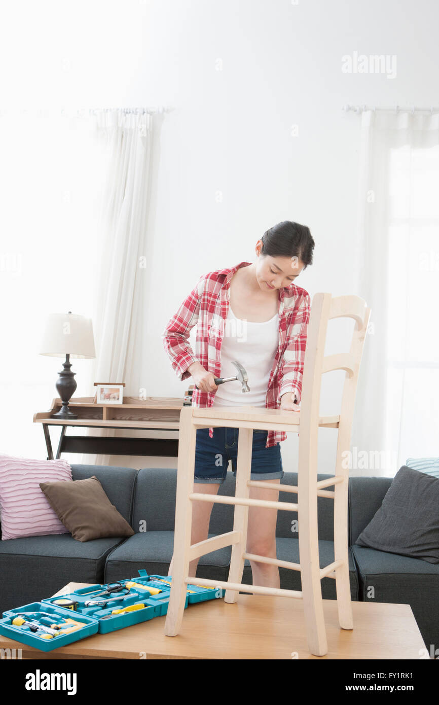 Young woman fixing a chair Stock Photo Alamy