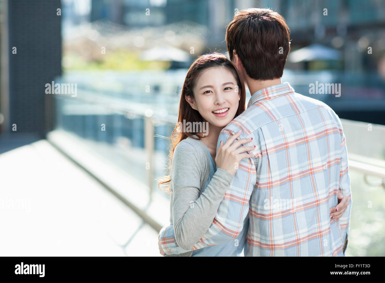 Portrait of young smiling couple hugging Stock Photo - Alamy