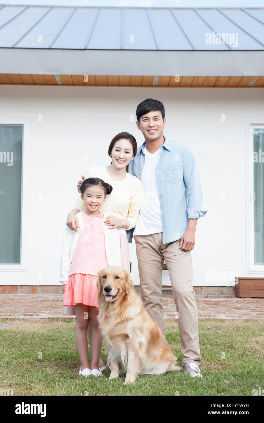 Family with a dog at the outside of their house representing rural life Stock Photo