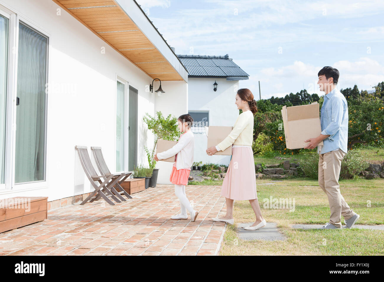 Girl and her parents moving together to the new house representing rural living Stock Photo