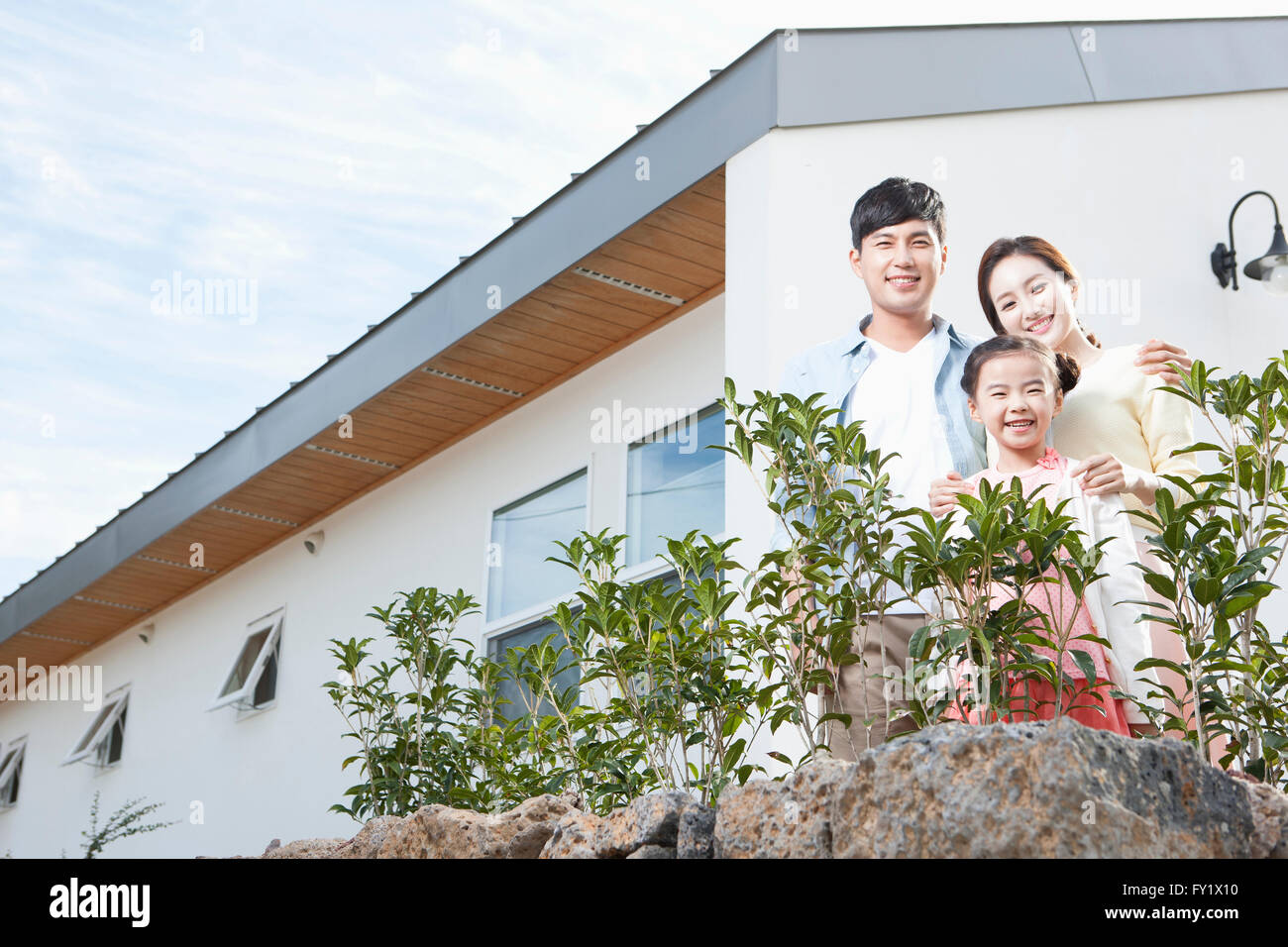 Family being happy at the yard of their house representing rural living Stock Photo