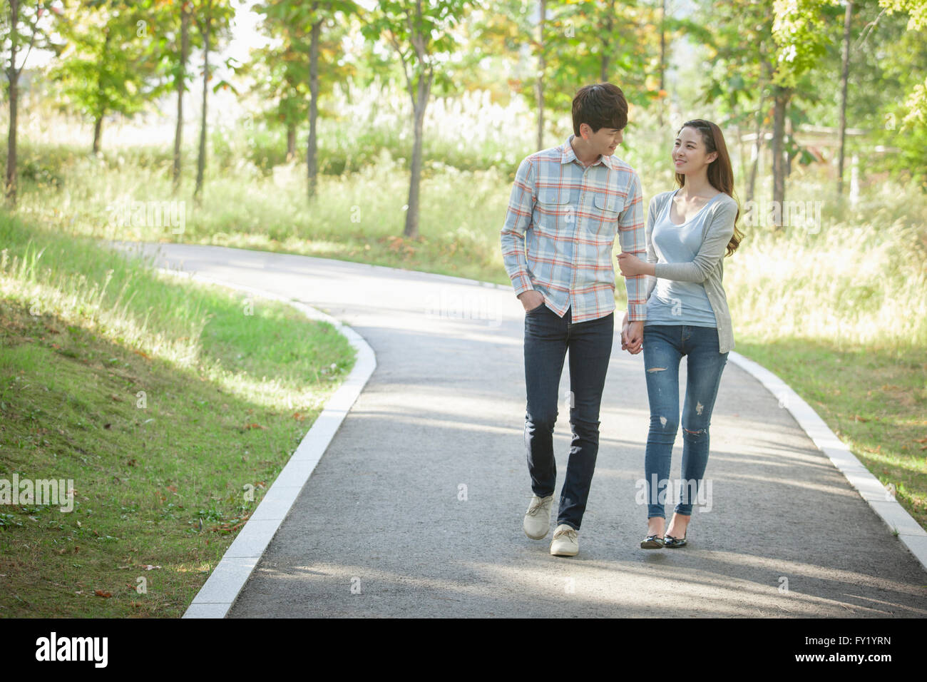 Couple walking hand in hand at the park Stock Photo - Alamy