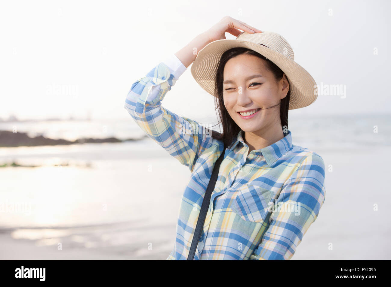 Woman in hat smiling forward at the beach Stock Photo - Alamy