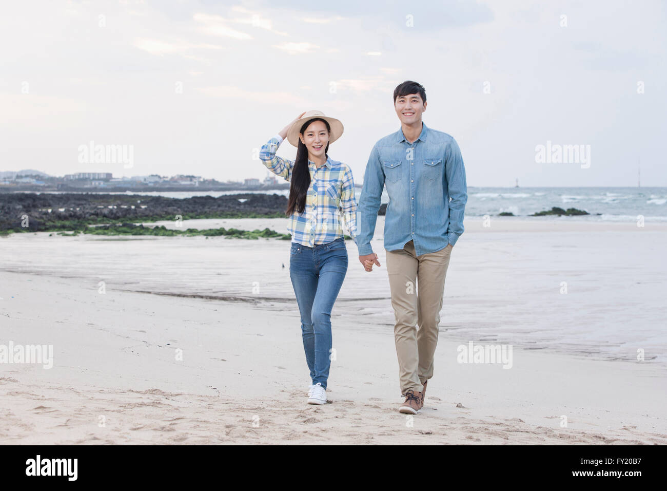 Couple walking hand in hand at the beach Stock Photo - Alamy