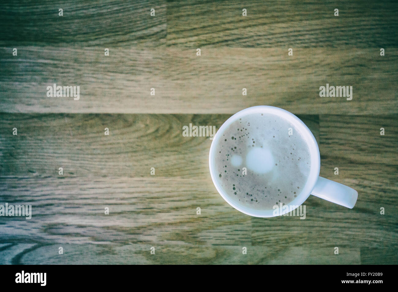 Colour image of a single cup of coffee on a wooden table. Stock Photo
