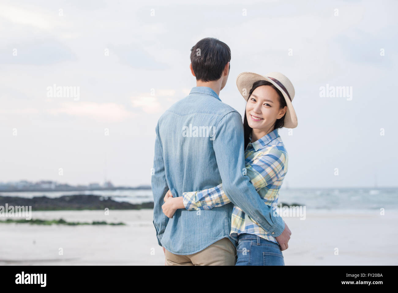 Woman hugging her boyfriend and smiling forward at the beach Stock ...