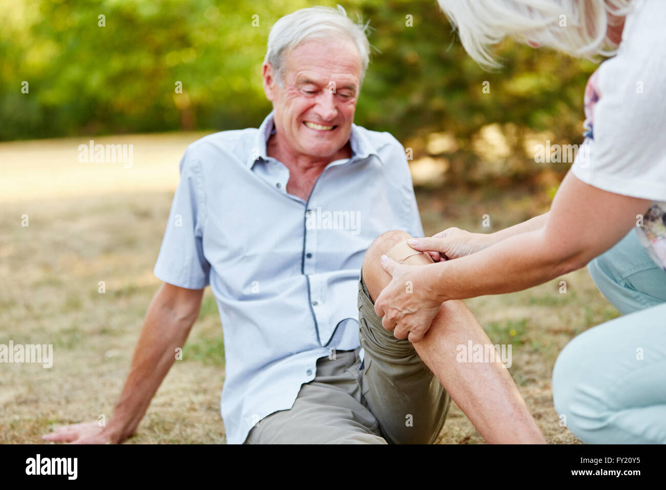 Old man with a knee injury gets plaster on his knee Stock Photo