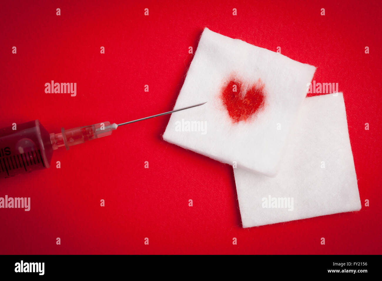 Heartshape of blood stain on a cotton and an infection filled with blood Stock Photo