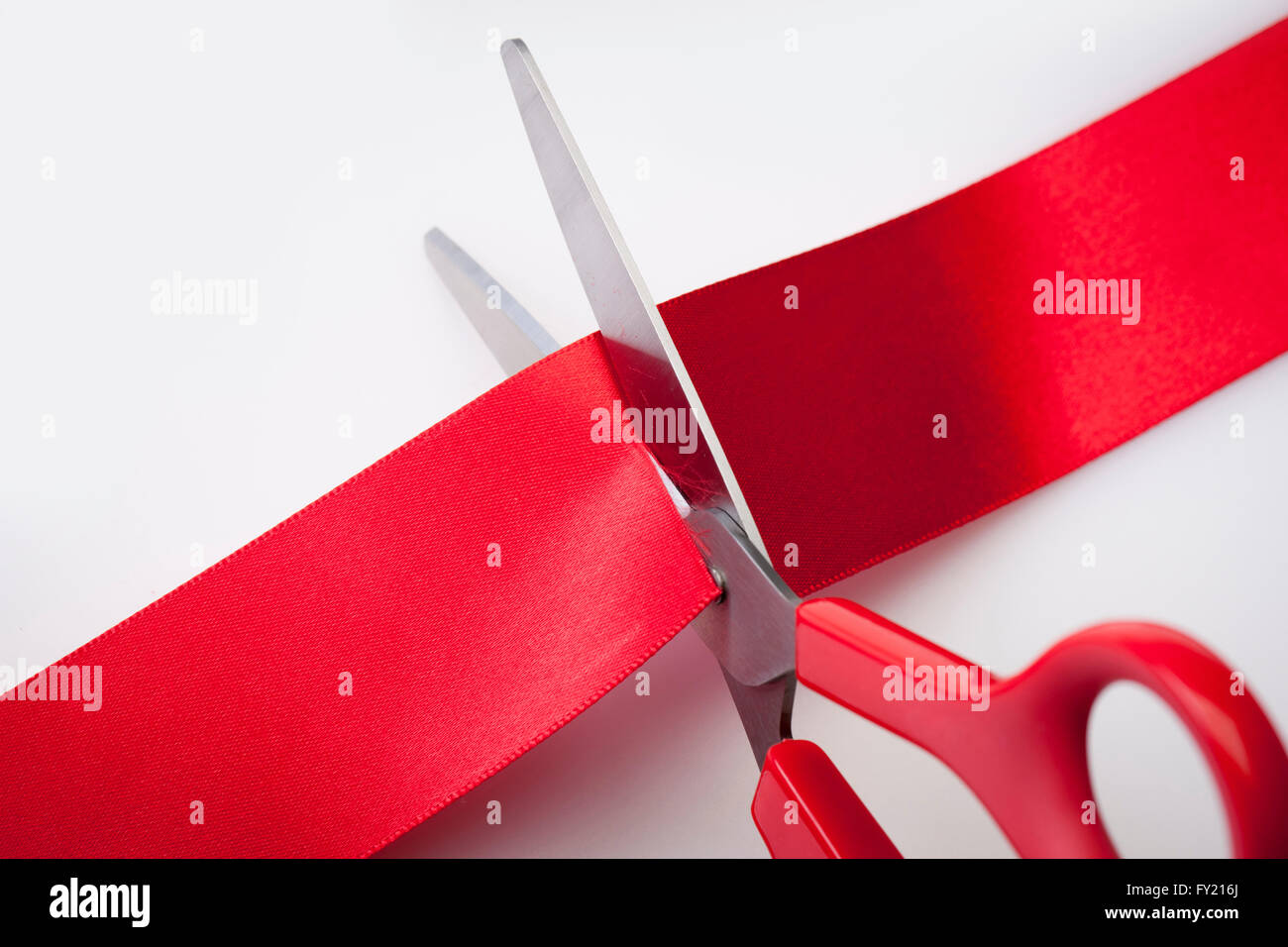 Red tape being cut by red scissors Stock Photo Alamy