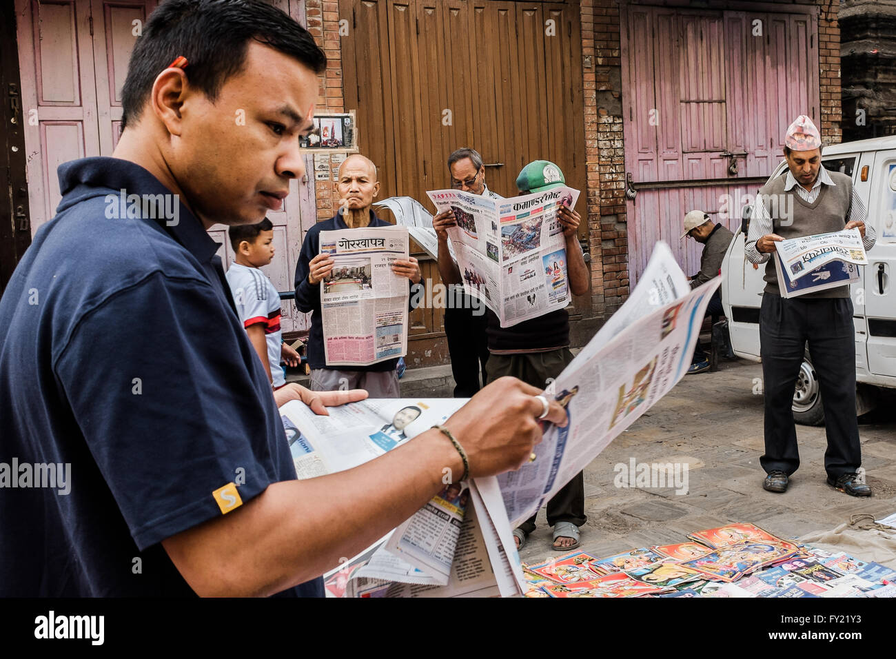 Group of men reading newspapers in the street of Kathmandu, Nepal Stock Photo