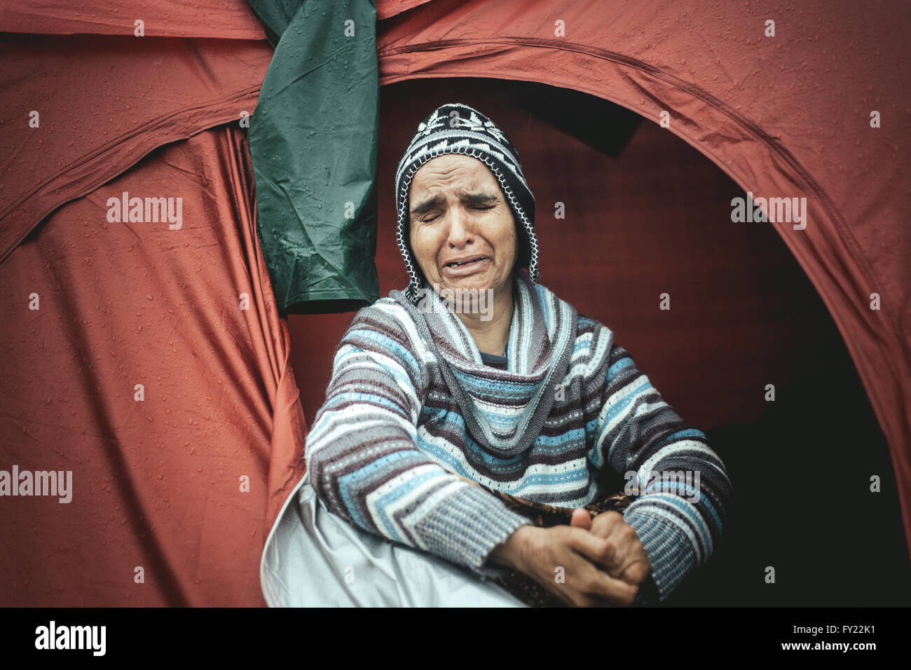 Desperate woman from Afghanistan weeping in her tent, refugee camp Idomeni, border with Macedonia, Greece Stock Photo