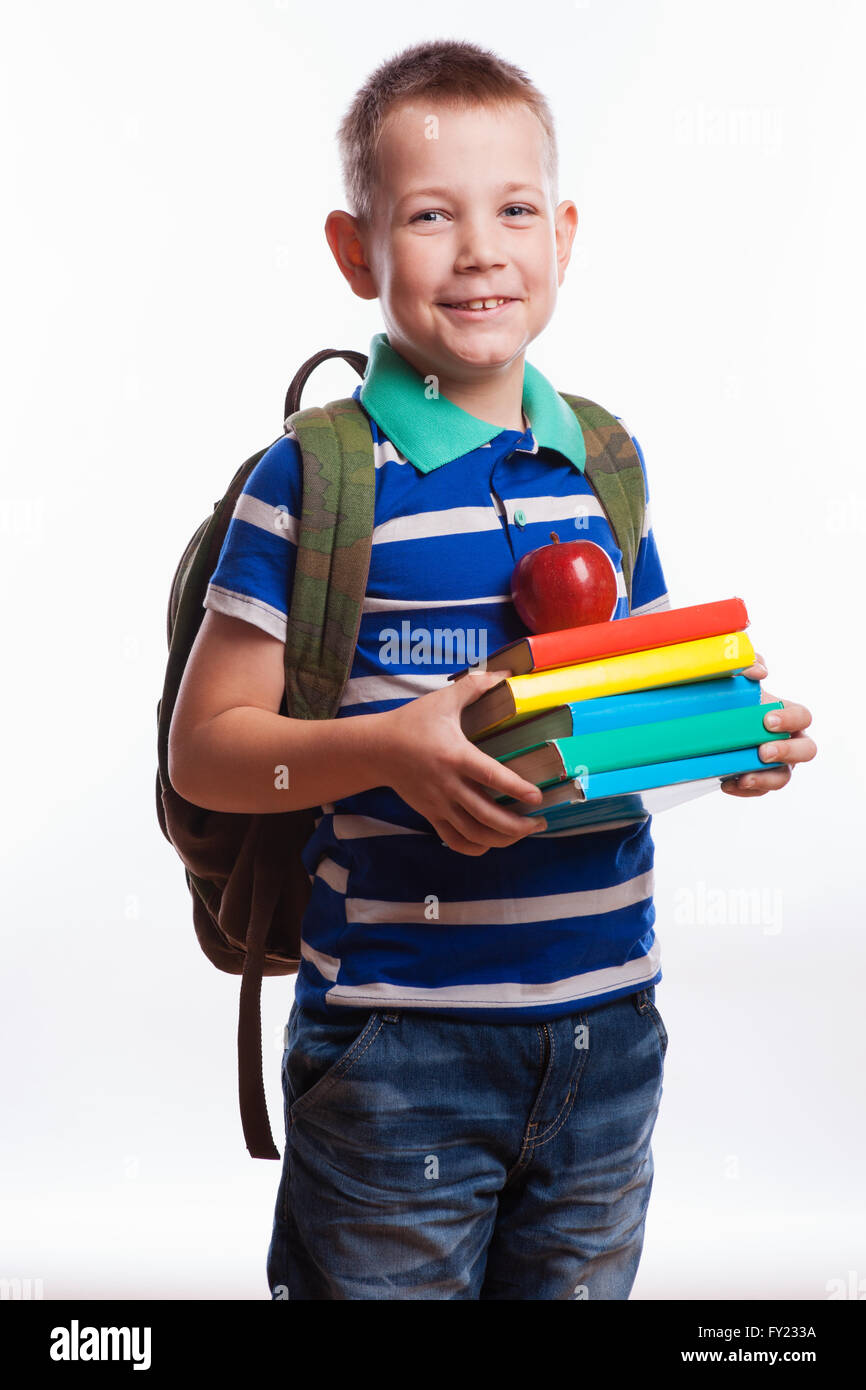 Young child holding stack of books and back to school written on chalk blackboard Stock Photo