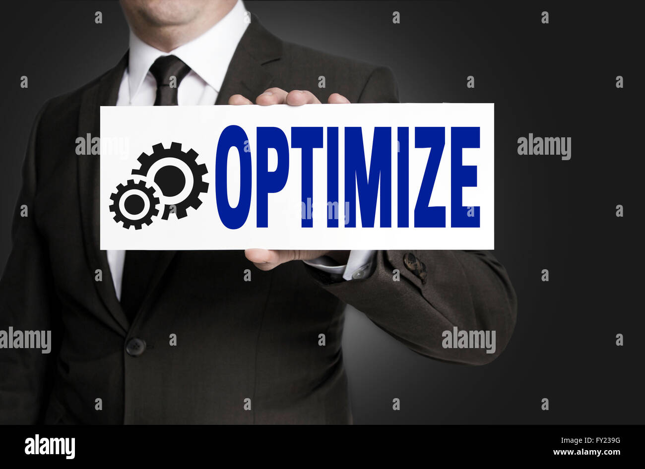 optimize sign is held by businessman background. Stock Photo