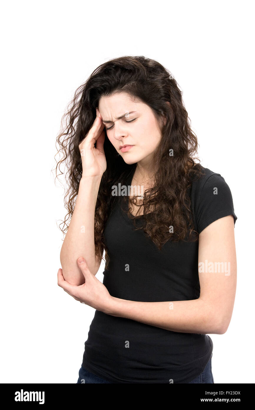 Young woman rubs the temple area of her head as she winces her face in pain from a migraine headache. Stock Photo