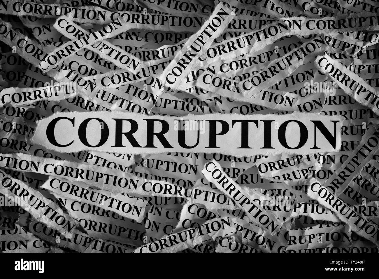 Torn pieces of paper with the word Corruption. Concept Image. Black and White. Closeup. Stock Photo