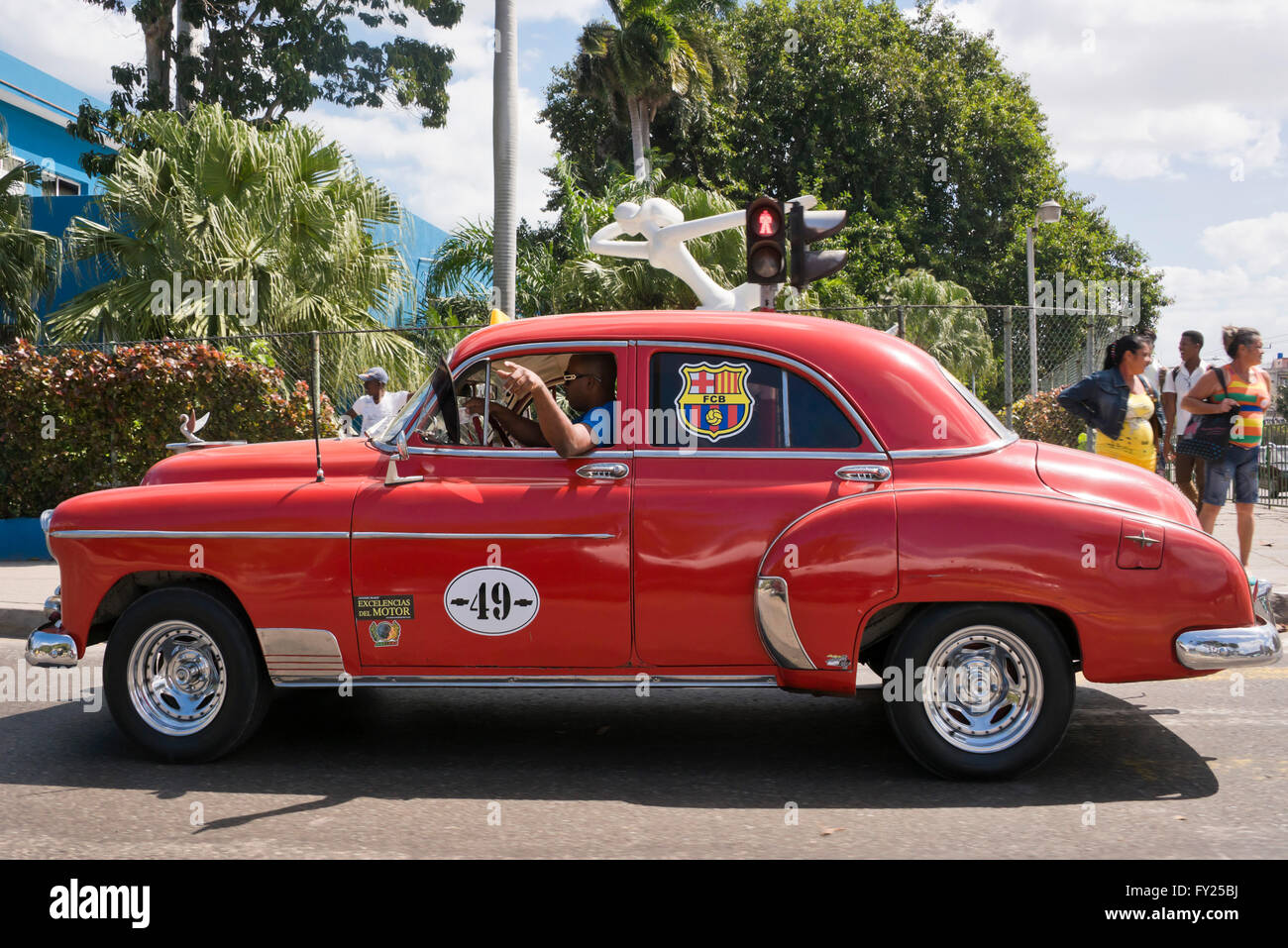 Horizontal view of a classic American taxi driving along a street in Havana, Cuba. Stock Photo