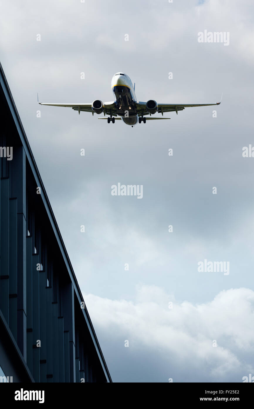 Jet flying over buildings Stock Photo