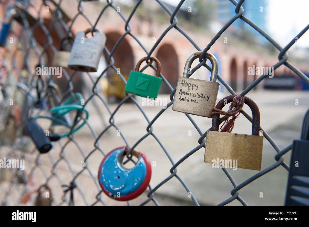 A collection of signed padlocks or love locks on a fence outside