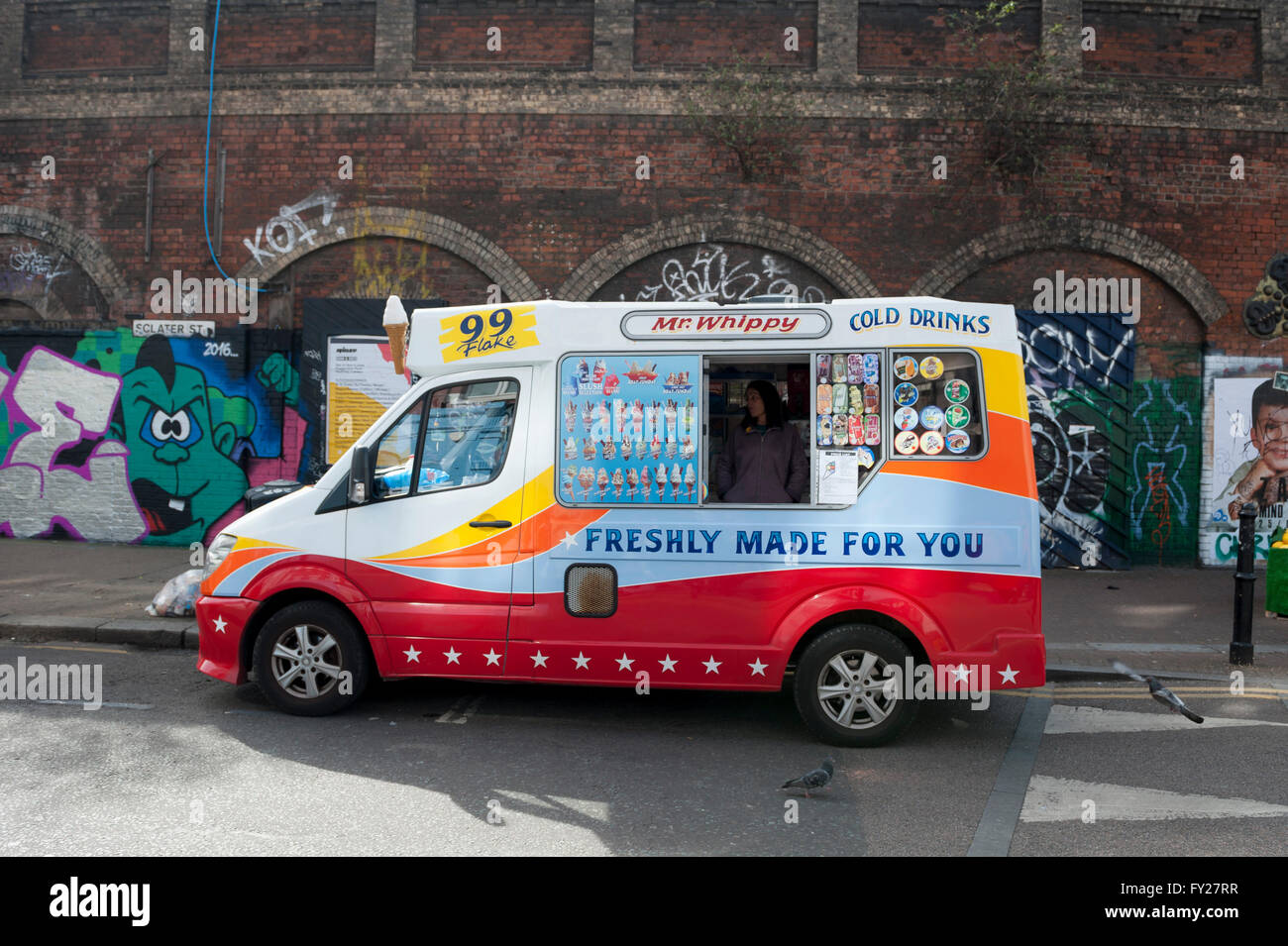 A colourful ice cream van in Shoreditch in front of some murals Stock Photo