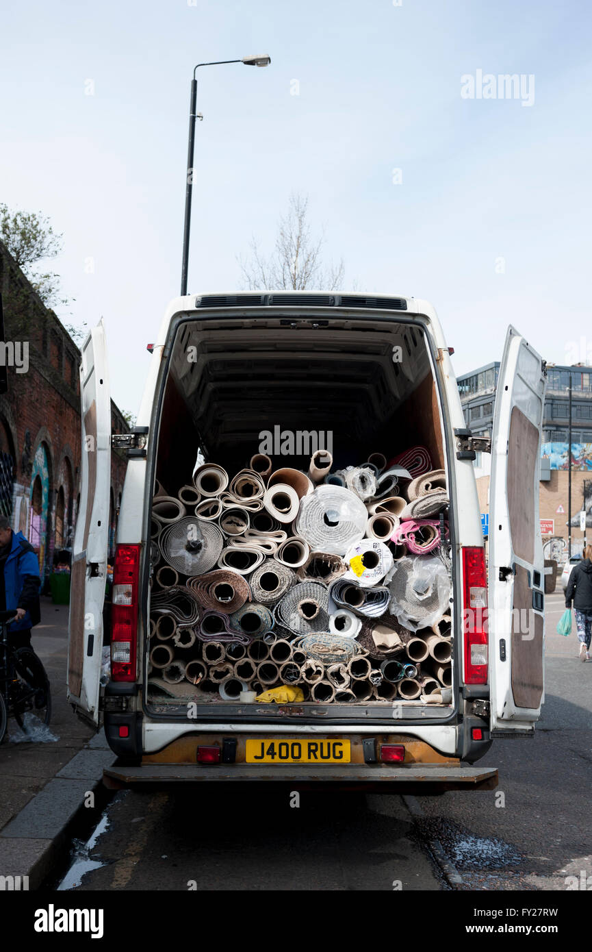 A van full of rolled up carpets with a personalised numberplate rug Stock Photo